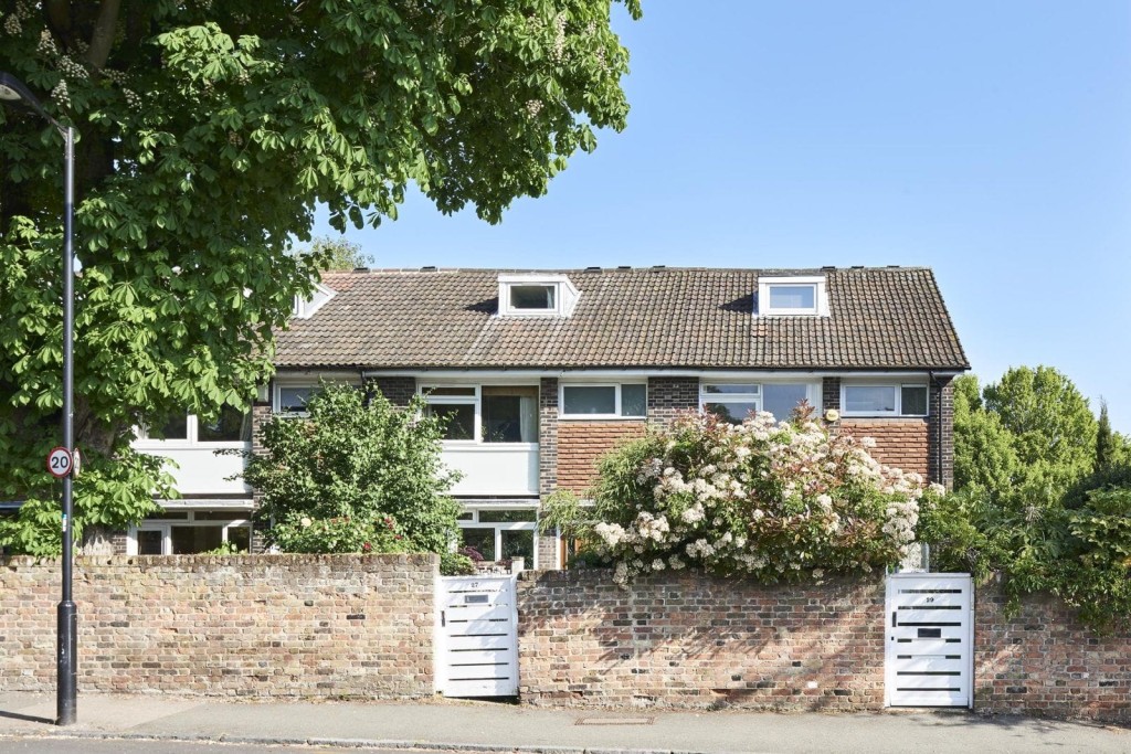 Brick house with a garden and white gates in Boston, MA