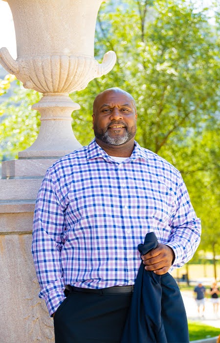 Close-up photo of a man in formal attire and smiling